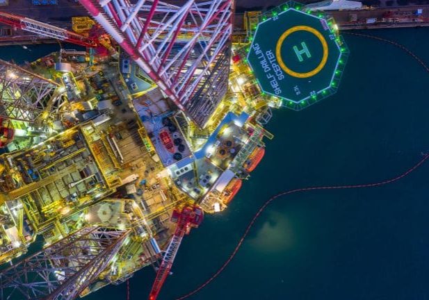 Aerial view offshore jack up rig  at night, Offshore oil rig drilling platform.