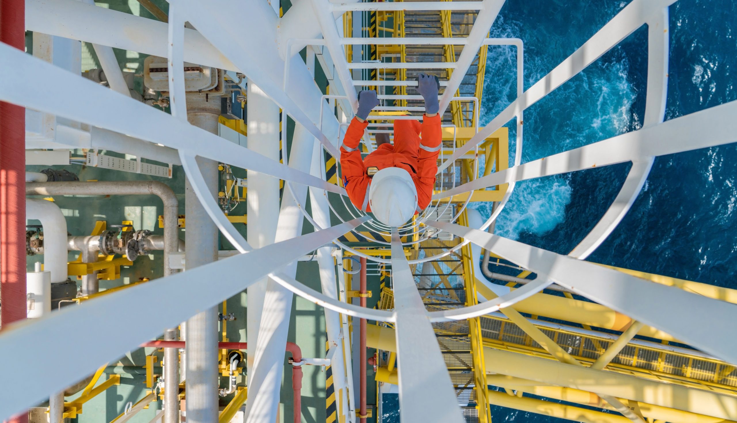 Offshore oil and gas production operator climb up to gas processing platform to checking condition of gases condensate treatment and utility process.